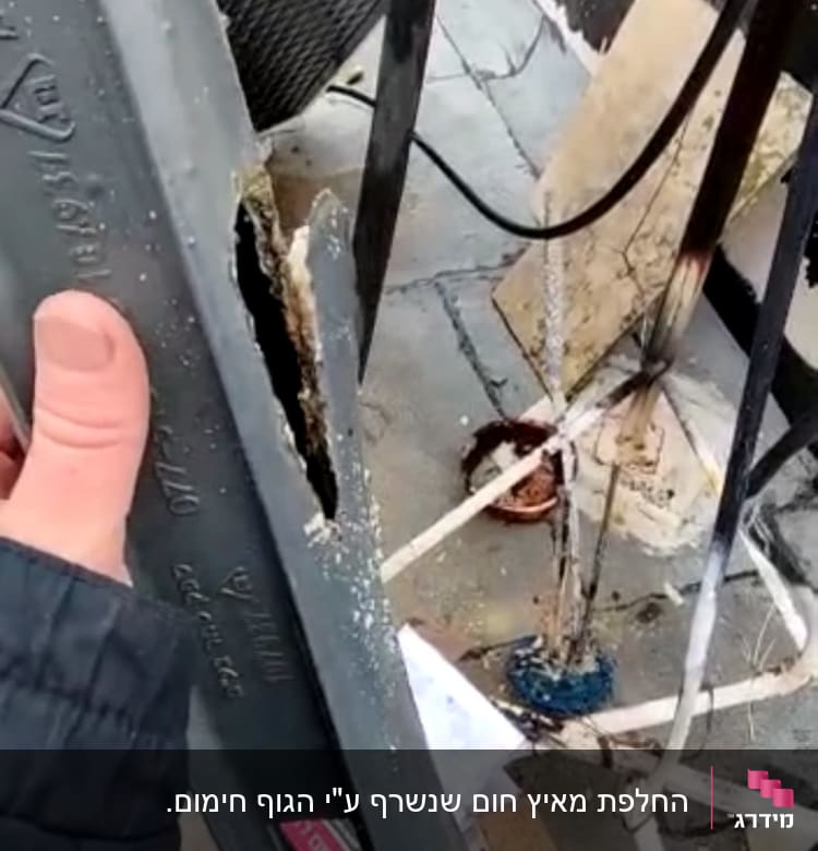 צינור סולארי פגום עם חור גדול, יד מחזיקה בצינור